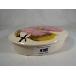 A Moorcroft Pottery lidded oval trinket box decorated with pink magnolia on an ivorine ground, 3.