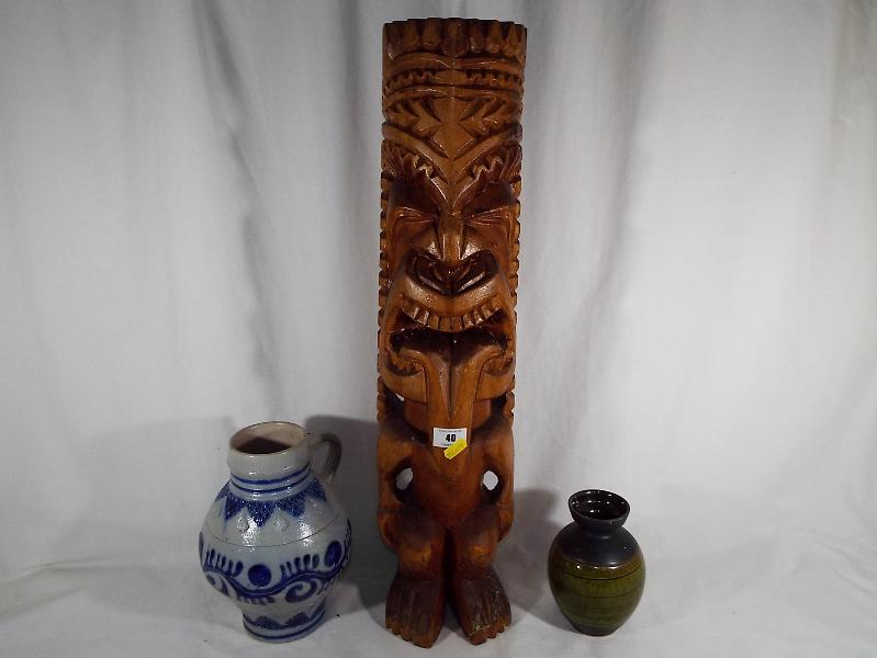 A carved wooden tiki head, 64cm (h), a German salt glaze stein,