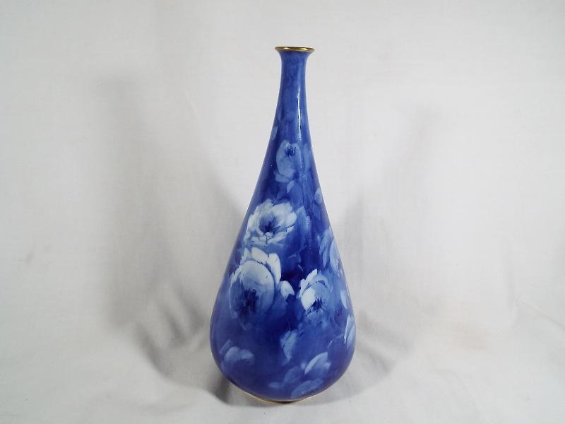 A Royal Doulton Corolian ware bulbous vase with a tapered neck decorated on a cobalt blue ground