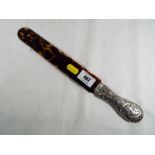 A Victorian tortoiseshell page turner with silver hallmarked handle with embossed depiction of
