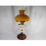 A ceramic oil lamp with glass funnel and reservoir,