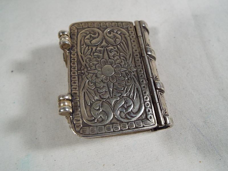 A silver vesta in the form of a miniature book with twin-internal compartments .800 - Image 3 of 5