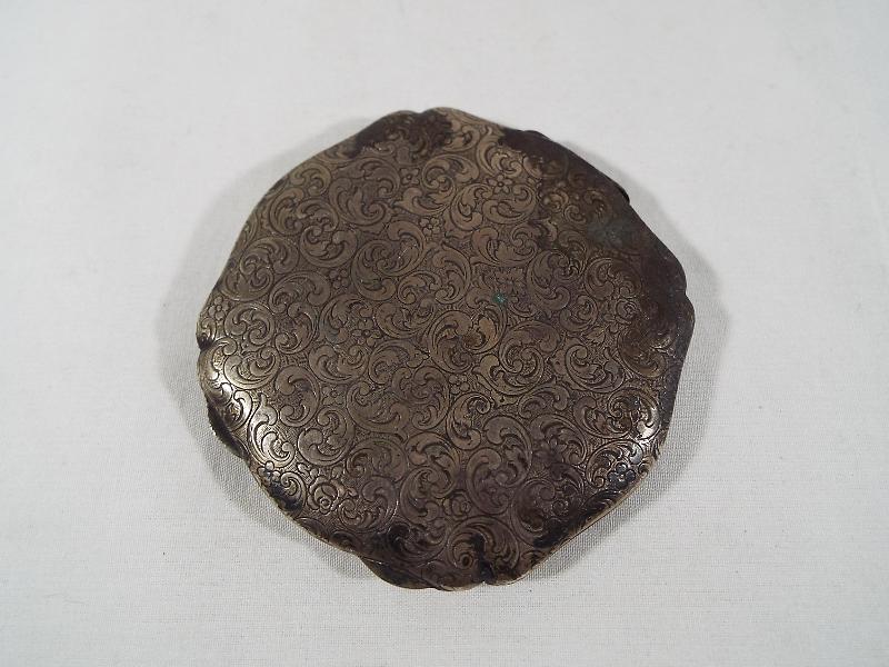 A German silver compact with engraved foliate decoration marked 835,