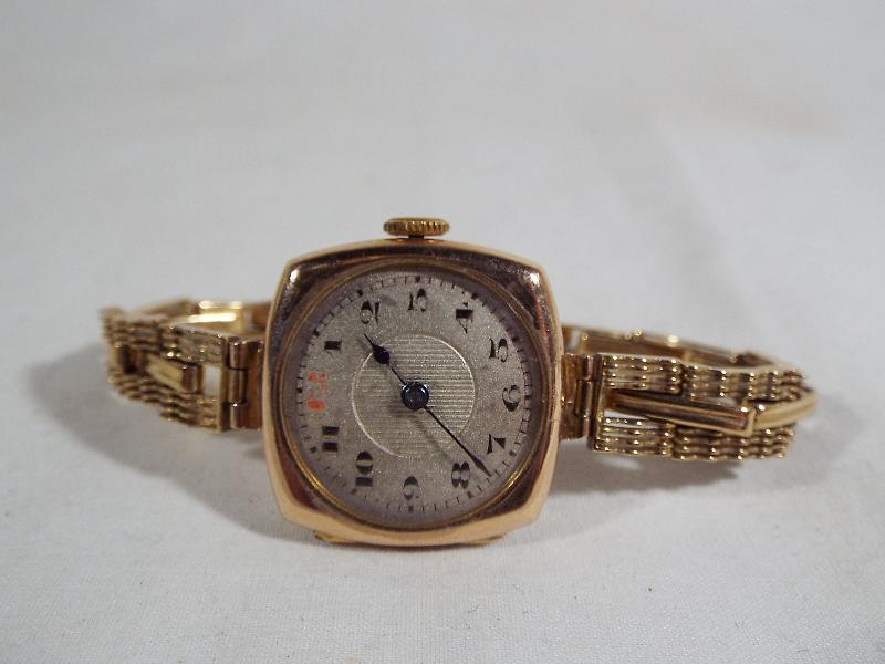 A lady's 9 carat gold cased, Art Deco styled wristwatch on a 9 carat gold expanding bracelet,