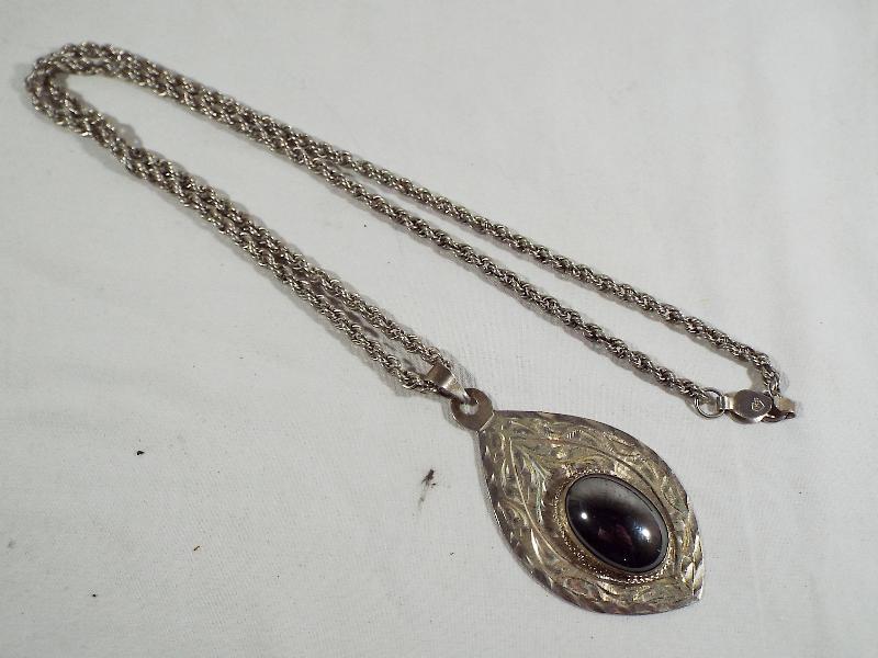 A lady's heavy silver necklace with unusual pendant,