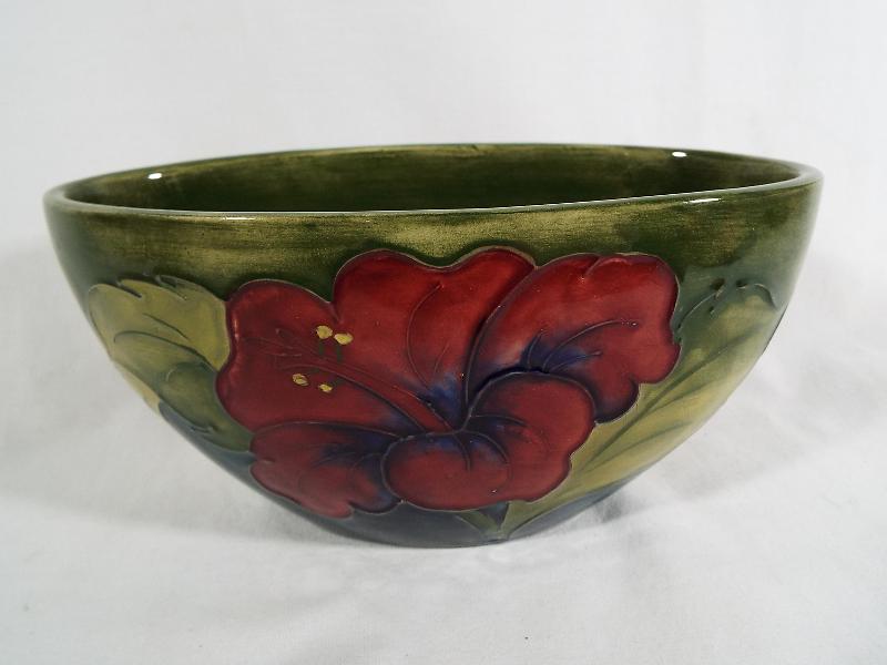 A Moorcroft Pottery oval planter decorated with coral hibiscus on a green ground,