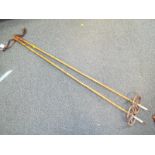 A pair of vintage cane skiing poles with leather grips,