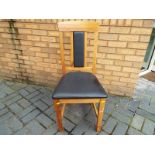 A pine dining chair with faux leather cushioned seat