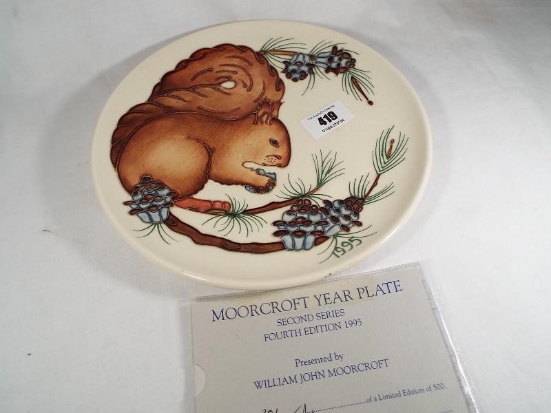 A Moorcroft Pottery 1995 year plate decorated with a depiction of a red squirrel,