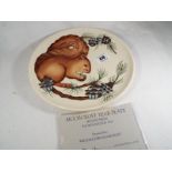 A Moorcroft Pottery 1995 year plate decorated with a depiction of a red squirrel,