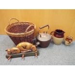 A wicker basket containing a large copper kettle,