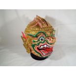 A Bolonese brightly coloured paper mache mask, on stand,