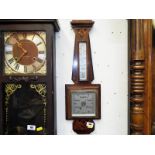 A wall mounted aneroid barometer and thermometer,