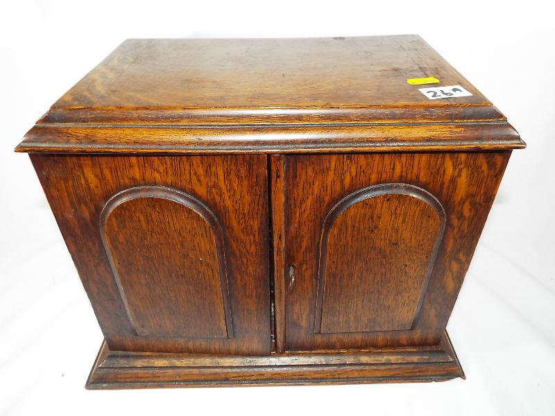 An smoker's oak cased cabinet with presentation plaque dated 1928,