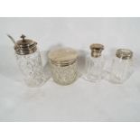 Four glass jars, all with hallmarked silver caps / mounts,