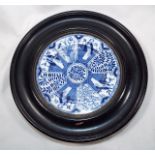 A Chinese blue and white plate mounted within a wooden circular frame marked verso with a blue