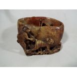 An unusual Chinese carved soap stone brush washer with depictions of monkeys including one monkey