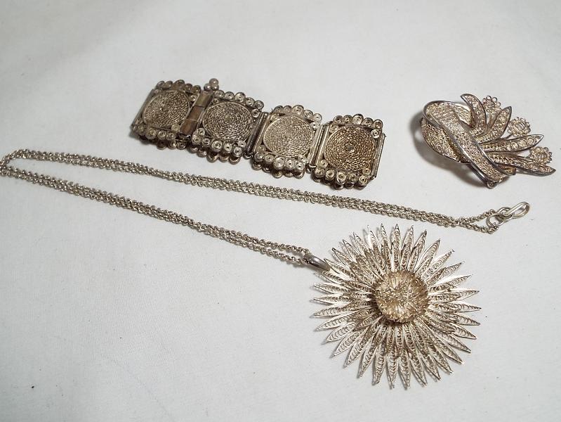 A lady's sterling silver filigree brooch in a floral design and a filigree Eastern style bracelet,