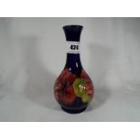 A Moorcroft Pottery solifleur vase decorated with hibiscus on a cobalt blue ground,