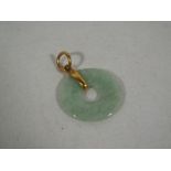 A lady's jade pendant with yellow metal surround,