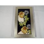 Moorcroft Pottery - A framed plaque decorated in a floral pattern, frame size 25cm x 14.
