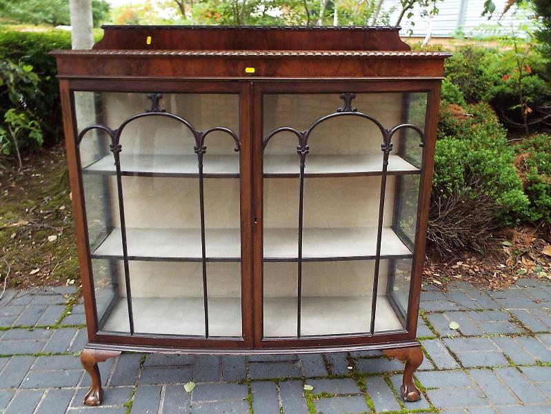 A mahogany bow-fronted display cabinet with astral glazed front doors,