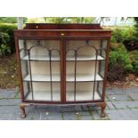 A mahogany bow-fronted display cabinet with astral glazed front doors,