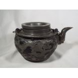 A Chinese Yixing pewter teapot decorated with dragons chasing a flaming pearl character marks to