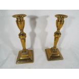 A pair of late 18th century brass candlesticks on square bases, 20.