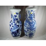 A large pair of blue and white Chinese vases decorated with flora and precious items.
