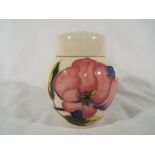 A Moorcroft Pottery lidded ginger jar decorated with pink magnolia on an ivorine ground, 11.
