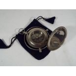 A white metal compass with single hinge protective cover,