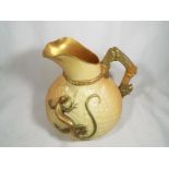 A Royal Worcester ewer / jug decorated with a depiction of a large gilded lizard on a blush ivory