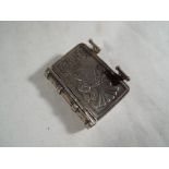 A silver vesta in the form of a miniature book with twin-internal compartments .800