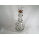 An unusual glass decanter with four stoppers,