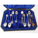 A display case containing a quantity of spoons to include four silver hallmarked spoons Est £20 -