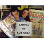 A box containing a collection of unsorted comics, magazines,