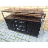 A modern sideboard, black gloss finish with chrome plated frame, twin doors, three drawers,