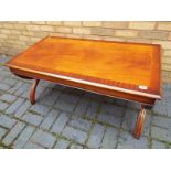 A contemporary mahogany coffee table with recency style legs 50cm (h) x 109cm (w) x 55cm (d)
