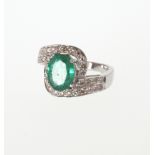 An Emerald and Diamond Ring. Set in high carat white metal stamped 585. Tests as 14 carat white