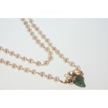 A Long Cultured Pearl Necklace. With Emerald set clasp in the form of grapes in a high carat