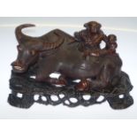 A good Chinese hardwood carving of a water buffalo, 19th Century, the large carved group depicting a