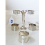 Five silver napkin rings and a silver bud vase