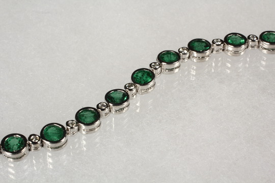 BRACELET - One 14K White Gold, Emerald and Diamond Bracelet with (23) round bezel set emeralds