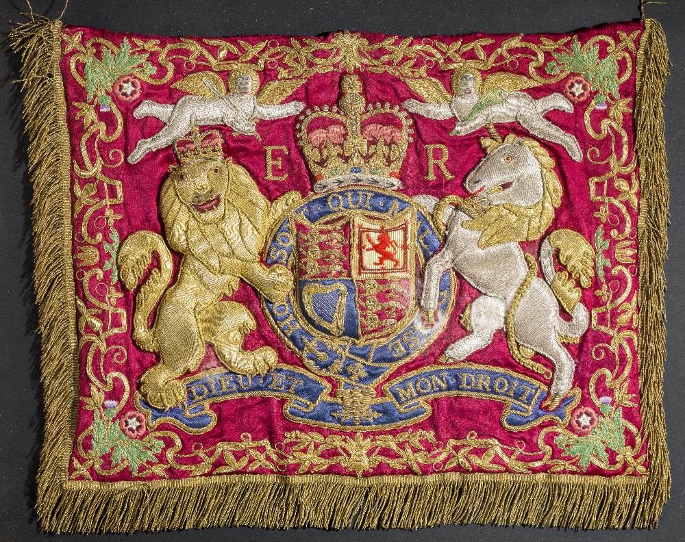 AN ELIZABETH II TRUMPET BANNER of red silk, embroidered with gold and silver thread with the crowned