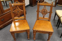 A pair of Victorian oak hall chairs.