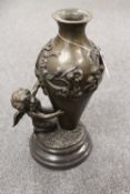 A bronze vase mounted with a cherub, on