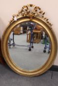 A nineteenth century gilded mirror, with bow decoration, height 103 cm. CONDITION REPORT: Small