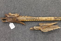 A carved bone blow-pipe with dragon deco