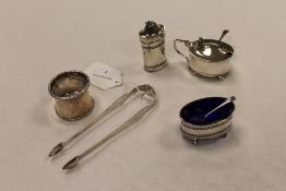 A pair of silver sugar tongs, together with three silver condiments and a silver napkin ring.  (5)
